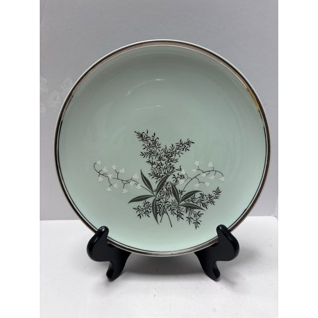 Elegant mid-century dinner plates in a soft celadon / mint green glaze featuring delicate black botanical foliage with...