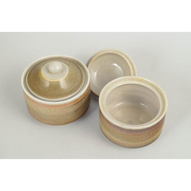 John Andersson for Höganäs, pair of lidded jars. Pair of thrown stoneware lidded jars with cylindrical bodies and fitted...