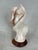 Carved pink alabaster sculpture depicting a Native American woman wrapped in abstract waves or flames. This sculpture was...