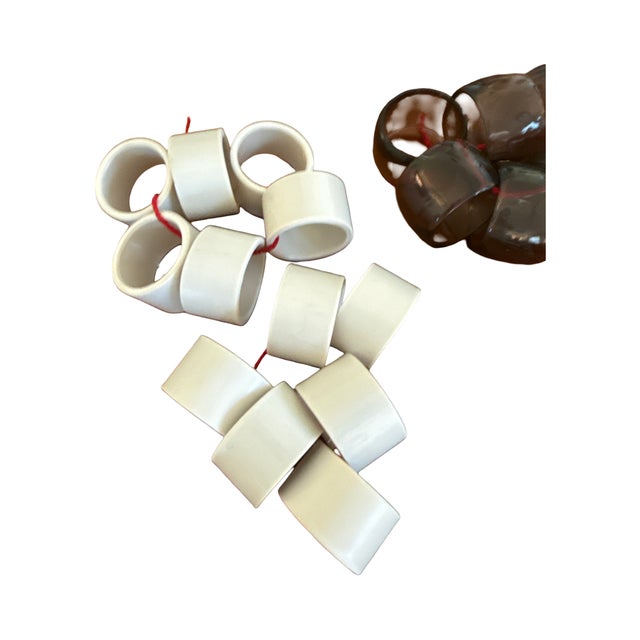 A curated vintage assortment of napkin rings in a mix of mid century materials and styles. This grouping includes...