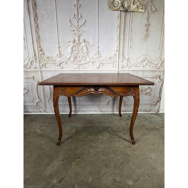An exquisite late 19th-century French Provincial center table in the Louis XV manner, rendered in warm, honeyed solid oak...