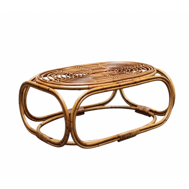 An oval Italian-designed coffee table in rattan and wicker, typical of the 1960s. The design is attributed to Tito Agnoli...
