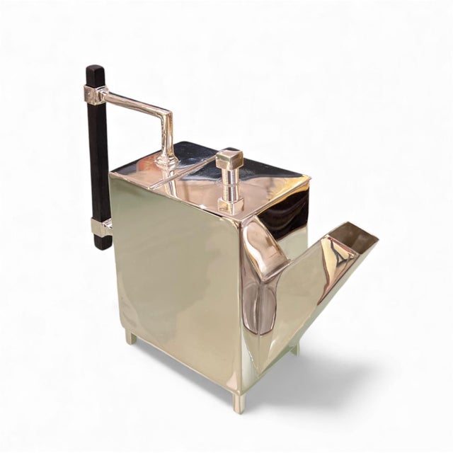 A cube-shaped alpaca teapot, a piece by the British designer Christopher Dresser, made around 1879-1882. Raised on four...