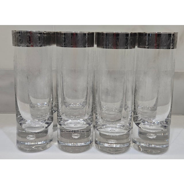 A handsome set of eight vintage highball glasses with silver overlay-style scroll rims, needle-etched floral decoration,...