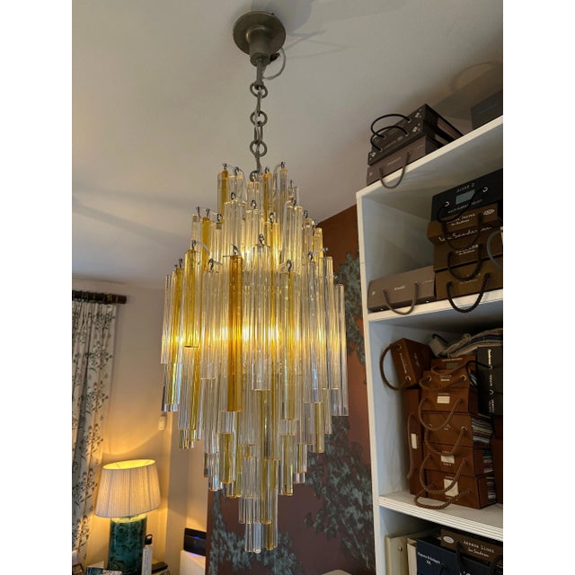 An Italian Murano glass pendant with clear and gold infused Murano Glass Trilobo pieces. Hung fro a white lacquered frame...