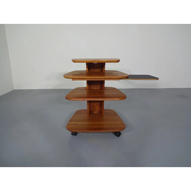This table has multi-level tiers and adjustable sides by Aksel Kjersgaard in solid teak. This piece has an attribution...