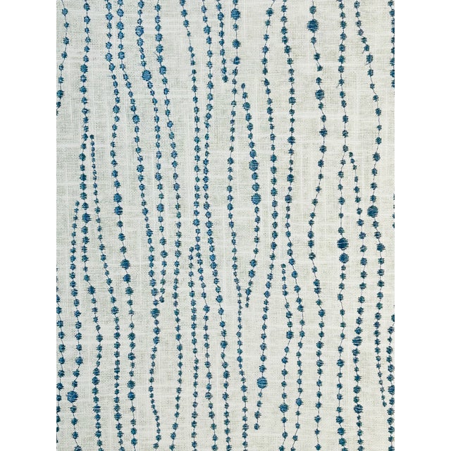Medium-blue embroidery on an ivory sheer, featuring delicate strands of varying-sized beads that appear to gently sway in...