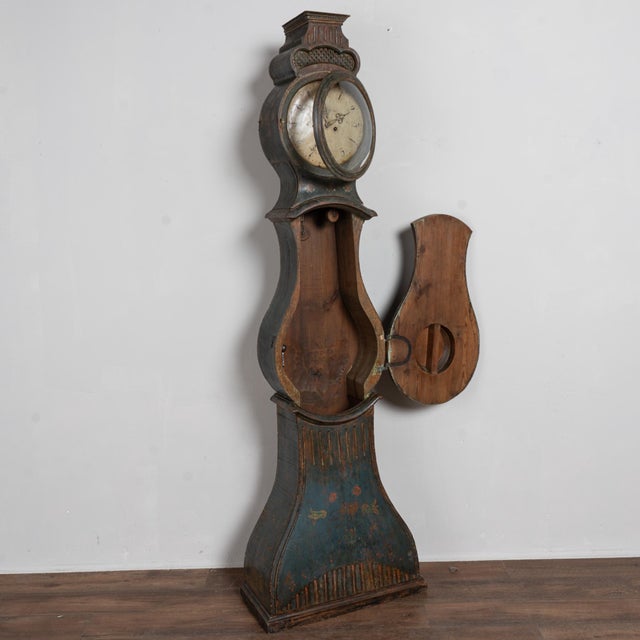19th-century Swedish Mora grandfather clock crafted in pine with an original painted finish. The surface is heavily...