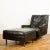 A Mid Century Modern black leather reclining lounge armchair with ottoman designed by Milo Baughman for James Inc,...