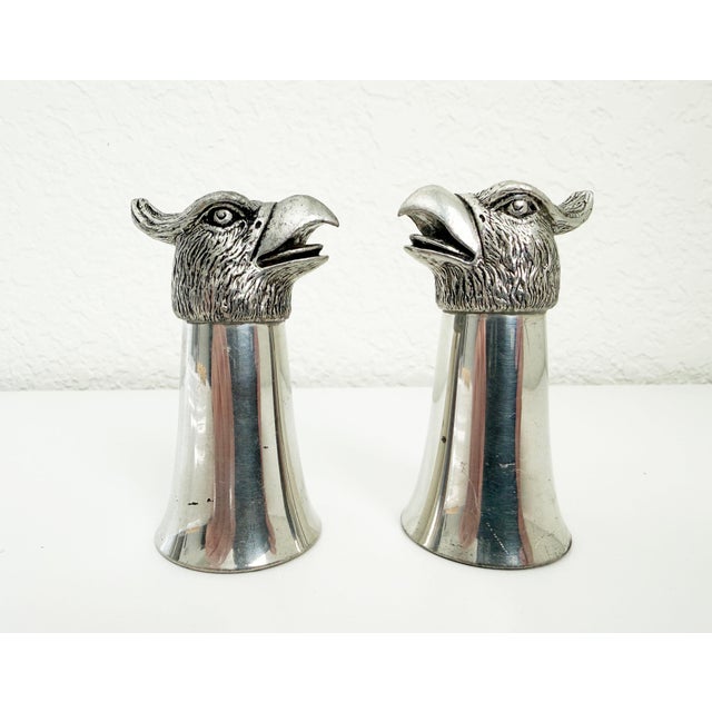 A festive pair of 3 oz stirrup cups (or double shot glasses) featuring a brushed steel cup and a pewter eagle's head....