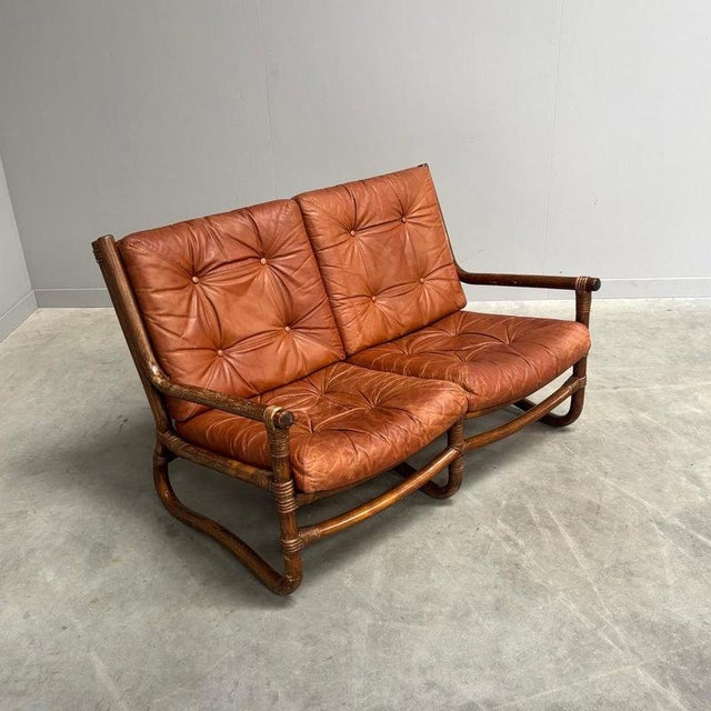 Danish sofa from the 1970s. Bamboo / manou frame with cognac leather cushions. Sofa is in good condition with patina and...