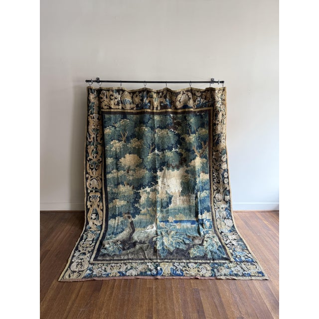 A French antique tapestry with ornate detailing, showcasing intricate patterns and rich textures. Its refined...