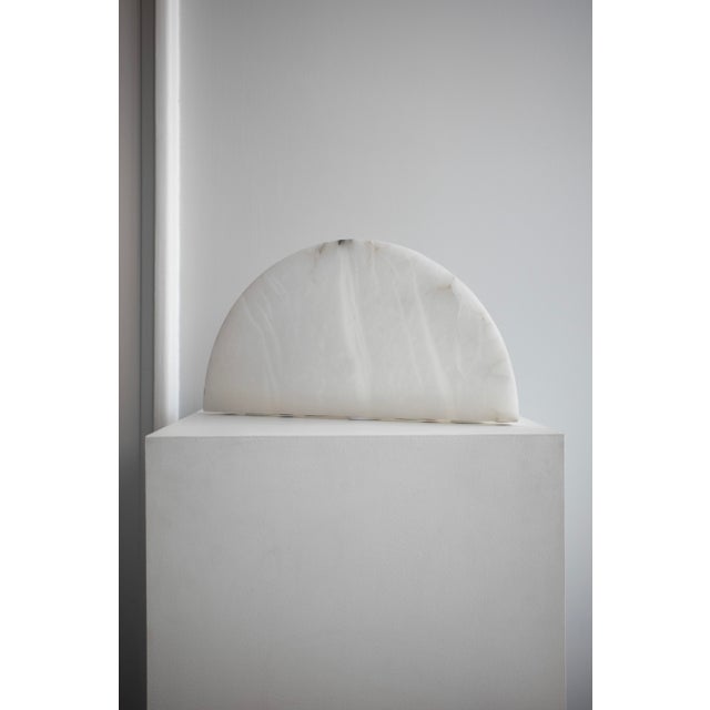 This elegant marble table lamp is the embodiment of timeless minimalism and natural beauty. The semicircular base with a...
