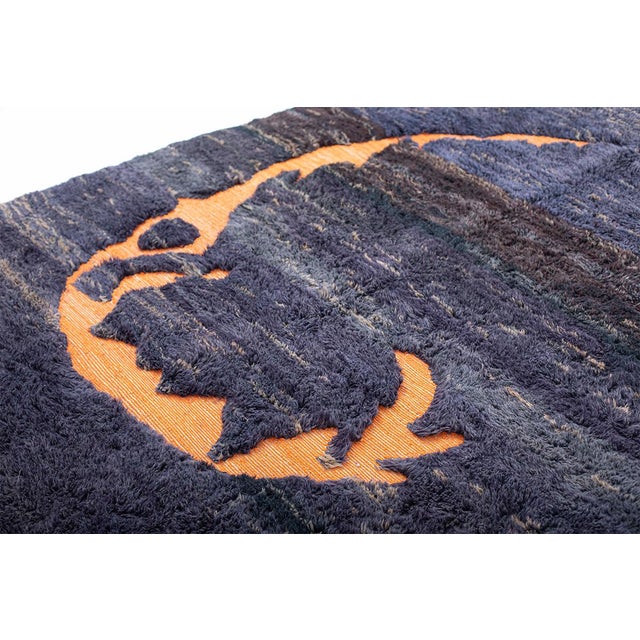 Creative hand-knotted wool rug in rich Evening Blue, Warm Gray, Hot Fudge, and Bluefin, accented by a vibrant Orange...