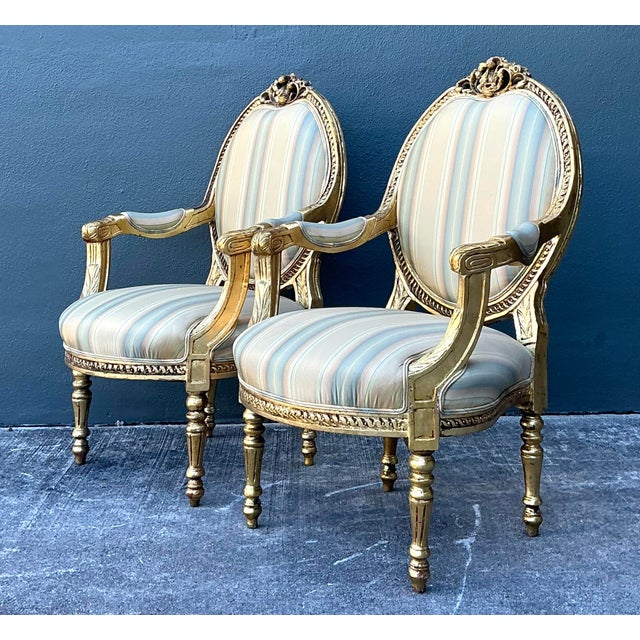 This exquisite pair of French Louis XVI style fauteuils epitomizes neoclassical elegance with a luxurious Hollywood...