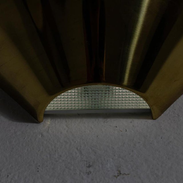 Description Wall light characterized by a fan-shaped diffuser in brass. The upper part is open and directs the light...