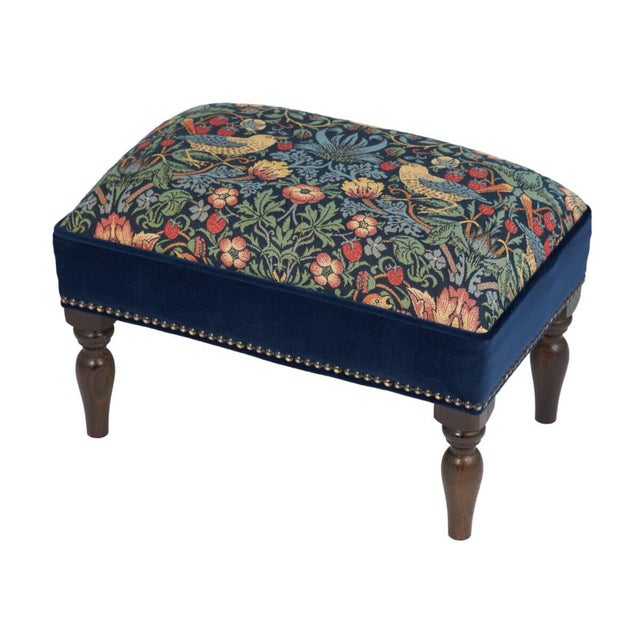Meticulously handcrafted in the United Kingdom, this upholstered stool boasts classic studding and hand-polished solid...