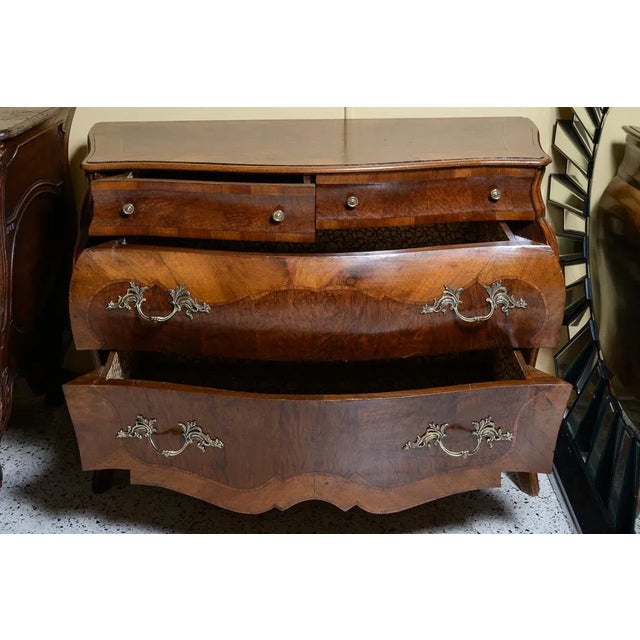 Italian walnut and burl walnut bombe chest. Two small drawers, two large drawers, and brass hardware. Scalloped front...