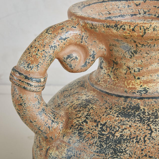 A large 19th Century terracotta vase sourced in Italy. Its gracefully curved handles and rounded body are textured with a...