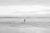 This timeless black and white beach photography print features a male figure wading into the water, eager for a swim in...