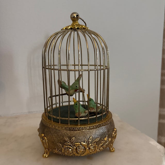 Stunning bird automaton featuring three ceramic birds in a brass cage. The brass pedestal of the cage is wonderfully...