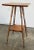 Handmade antique two tier side table with four petite turned splay wood legs attached by lower stretcher shelf. Square top...