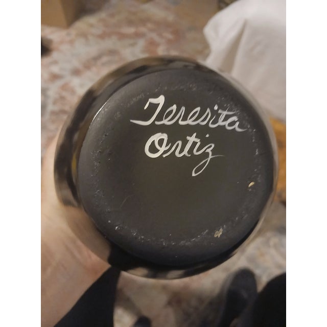 This is a Vintage Native American Blackware Pottery Bowl signed by artist, Teresita Ortiz. The bowl edpicts 2 blue eyed...