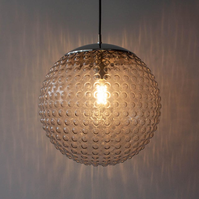 This pendant lamp, model p117, was designed by rolf krüger for staff, in germany, during the 1970's. it features a a...