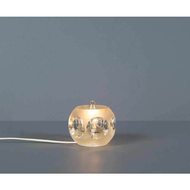Peill & Putzler solid glass table lamp from the 1970s. Outside and inside the cube has a matt surface. A glowing, diffused...