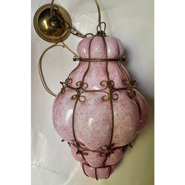 This is an absolutely fantastic white glass cased in mottled pink glass, hand blown into a wire cage which, when lighted...
