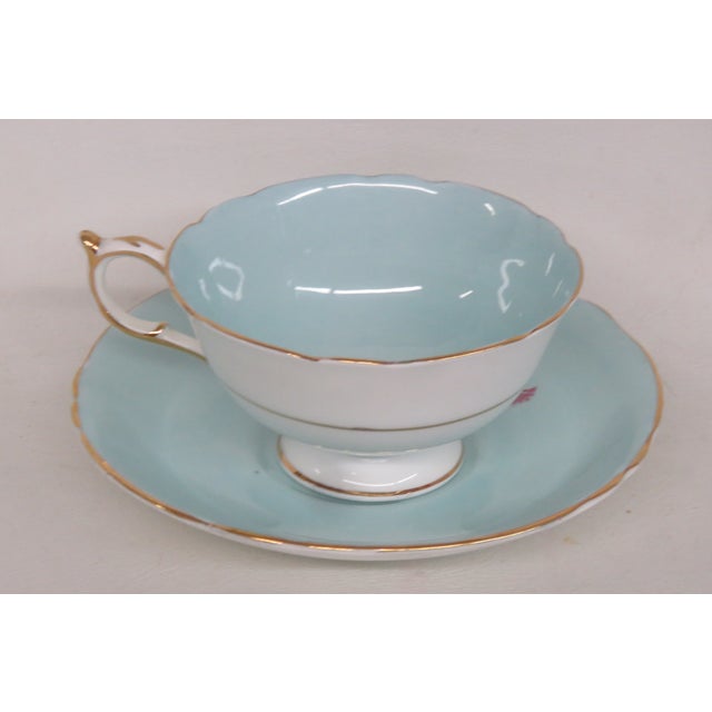 This beautiful footed teacup and saucer has the maker's mark "Paragon, England" on the underneath, as well as the double...