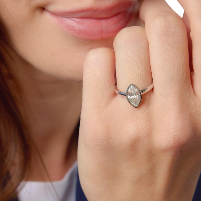 This elegant modern engagement ring showcases a striking 1.55 carat marquise cut diamond, certified by GIA #2221183960,...