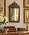 A wonderfully detailed antique French cast brass mirror dating to the early 20th century, featuring an elaborate heraldic...