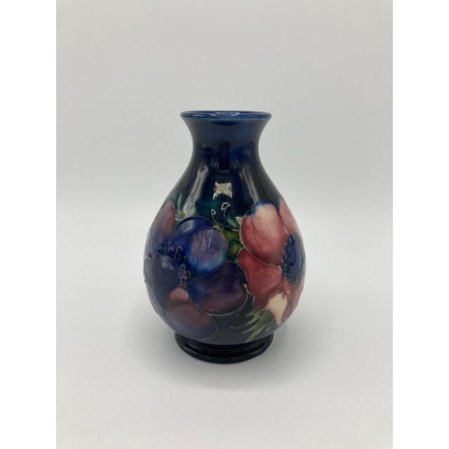 This is a small vintage bud vase by Moorcroft with anemones on a dark blue/cobalt background. It is approximately 5" tall...