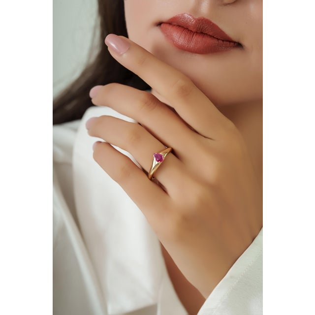 This dainty signet ring features a 0.42 carat natural ruby Set in 14K yellow gold. The ruby measuring 4 x 6 mm, securely...