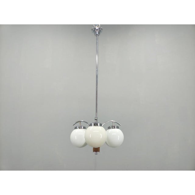 An elegant Art Deco chandelier produced in Czechoslovakia during the 1930s, featuring a sophisticated combination of...