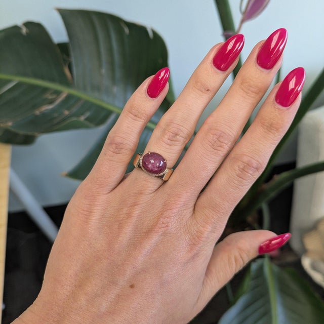 A remarkable 8.36-carat star ruby displays a six-rayed star across its domed cabochon, set in solid 14K yellow gold with...