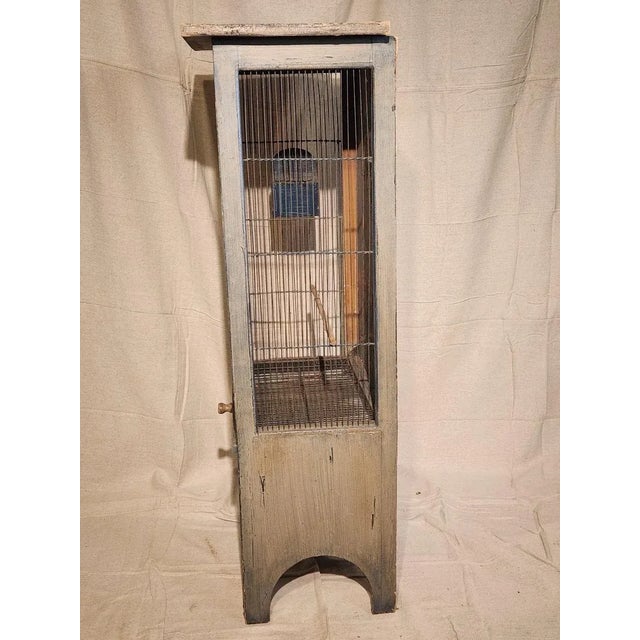 Fabulous vintage standing birdcage. Worn teal colored paint. Thin wired front and sides and unbelievable hand painted back...