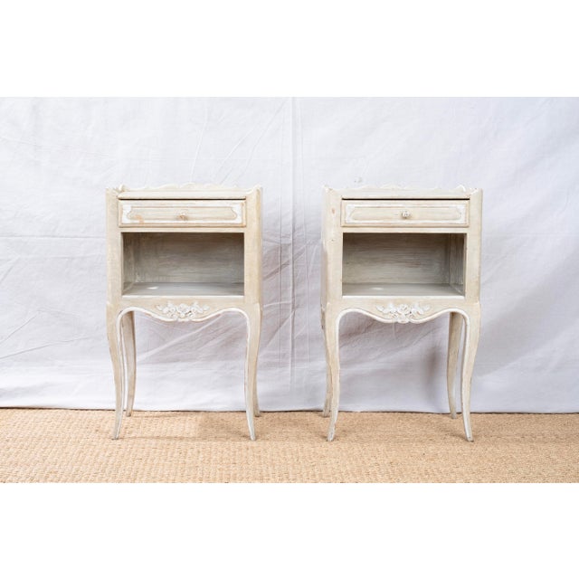 A pair of hand painted side or bedside tables, Louis XV style, c. 1890, French. Both feature a single drawer with matching...