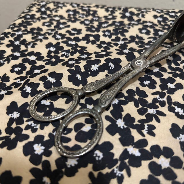Elevate your table service with these exceptionally ornate scissor-style tongs. Crafted with a heavy silver plate, this...