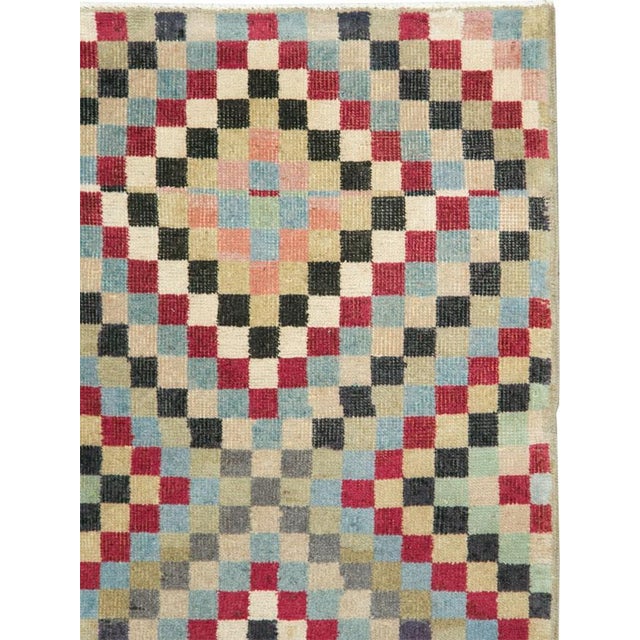 This mid-20th-century Turkish Anatolian rug presents a lively checkerboard composition formed from small, evenly scaled...