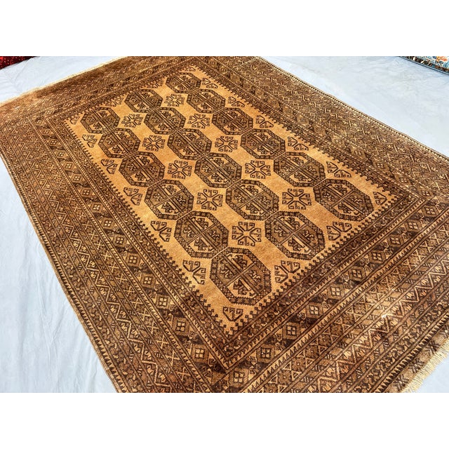 This warm Ersari rug features three columns of large octagonal gul medallions, each filled with stylized leaf and floral...