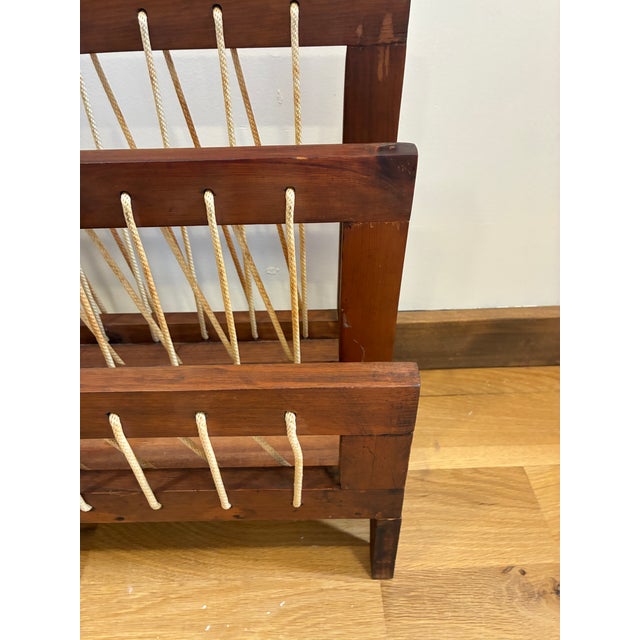 A unique vintage find for the collector of mid-century design — this wooden magazine rack features a solid wood frame with...