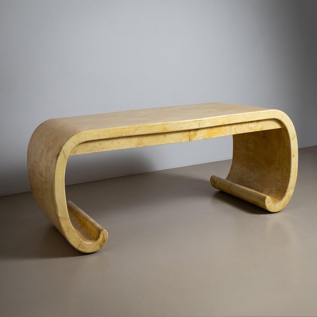 An elegant and spacious desk attributed to Karl Springer. The piece features a distinctive scroll-shaped design and...