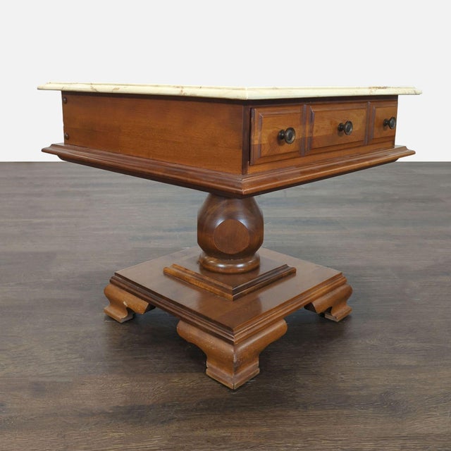 One drawer table on pedestal base. Dimensions (in): 24W x 24D x 22H.