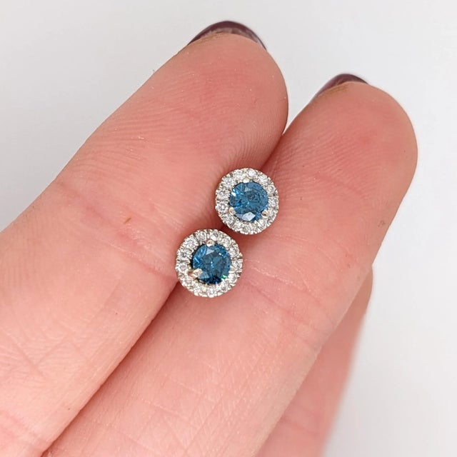 These classic design stud earrings feature two round 0.36 cttw blue diamonds with natural earth mined diamonds in all...
