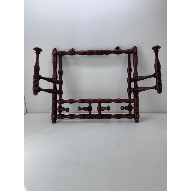 This spindle style rack is carved of solid walnut. There are 2 swinging hat pegs and 4 moving pegs for coats &...