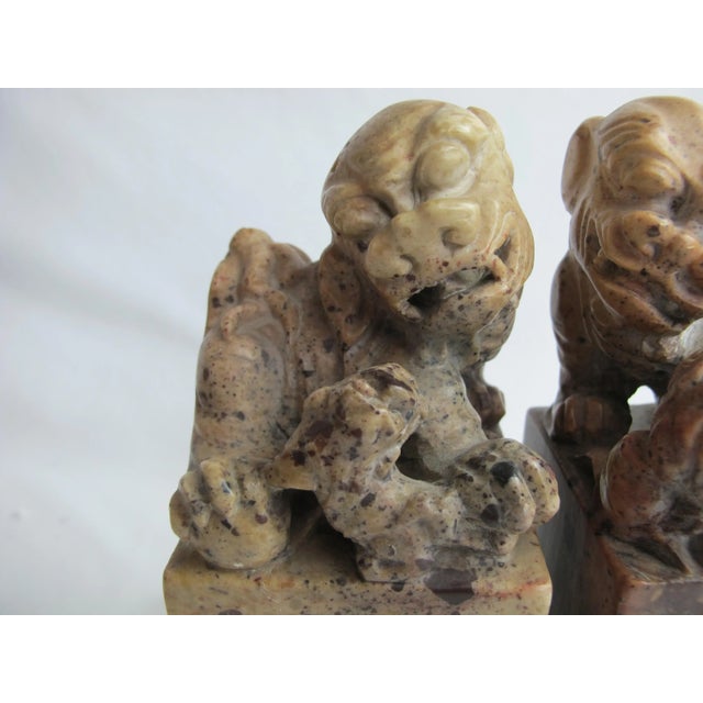 Pair of Chinese Foo Dog carvings in tones of brown hard stone. Each measures 8" tall x 2.75" x 2.75". Excellent condition,...