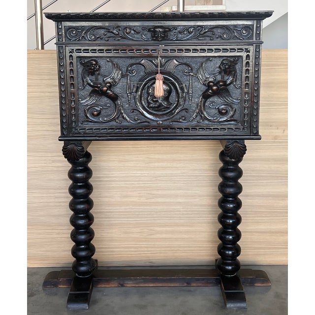 This Bargueno is embellished with a carving of Don Quixote de la Mancha bordered with branches of leaves. The desk is...