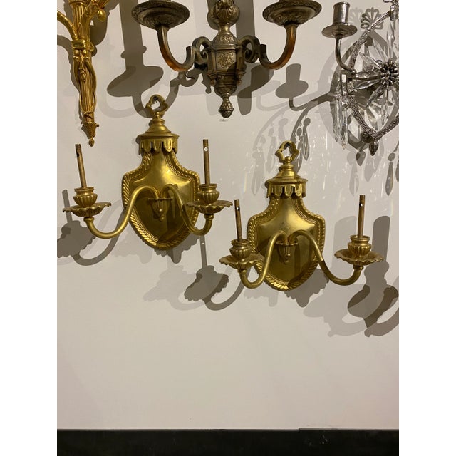 A pair of circa 1900 gilt bronze sconces with shield backplate, original finish and patina